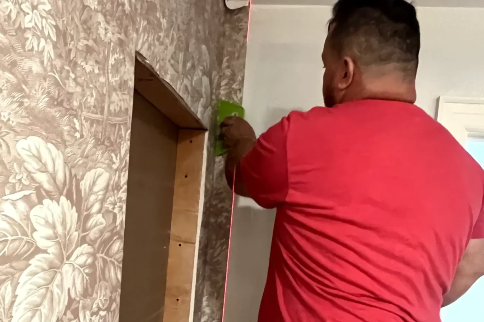 Close Up Of A Professional Applying Wallpaper In A Small Bathroom Showcasing Precision And Quality